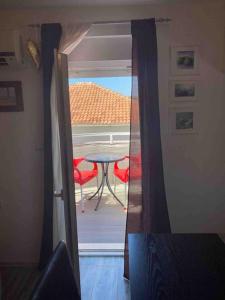 a room with a view of a table and red chairs at Apartment near the beach in Split