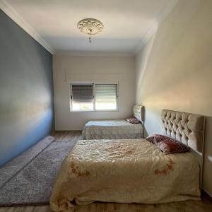 a bedroom with two beds and a window at Ajloun Rest House in ‘Ayn Jannā