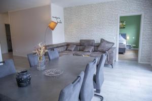 ein Wohnzimmer mit einem Sofa, einem Tisch und Stühlen in der Unterkunft Ferienwohnung Moseltraum, 1-6 Pers, mit 3 Schlafzimmer und Panoramabalkon in Müden