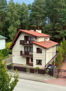 ein großes weißes Haus mit rotem Dach in der Unterkunft InOut Olsztyn in Olsztyn