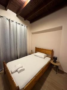 a bedroom with a bed with white sheets and curtains at Isabellas' home in Alepou