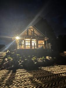un hombre parado frente a una casa por la noche en Domek Survivalowy w Spale, en Spała