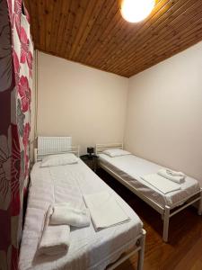 two twin beds in a room with a wooden ceiling at Isabellas' home in Alepou