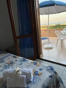 um quarto com uma cama com toalhas e um guarda-chuva em STELLA DI MARE em Marina di San Vito