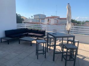 a patio with a couch and chairs and an umbrella at Maison La Nina in Campomarino