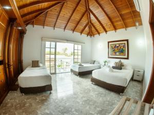 a bedroom with two beds and a large window at Hotel Koray in San Andrés