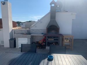 a fireplace on a roof with two chairs and a table at Maison La Nina in Campomarino
