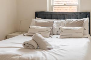 a white bed with pillows and a blanket on it at Henley town centre with parking in Henley on Thames