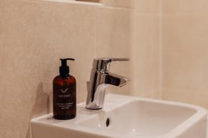 a soap bottle sitting on top of a bathroom sink at Henley town centre with parking in Henley on Thames +22 photos