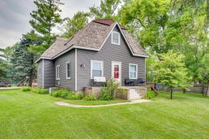 une maison grise avec une porte rouge sur une cour dans l'établissement Charming Eagle Grove Farmhouse with Patio!, à Eagle Grove