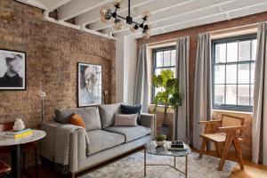 a living room with a couch and a brick wall at COVE Arne Street in London