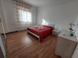 um quarto com uma cama vermelha e piso em madeira em Kalisa Home, B&B e Casa Vacanza Palermo em Capaci