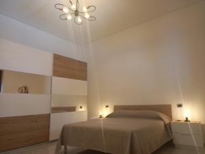 a bedroom with a bed and two lights on the wall at Le tre coccinelle in Porto Cesareo