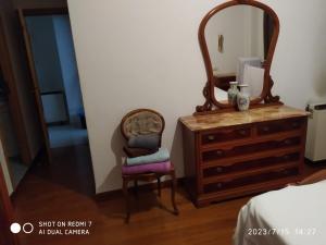 a bedroom with a dresser and a mirror and a chair at Apartamento calle Sainza 2 in Ourense