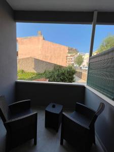 a balcony with two chairs and a large window at MaLuNa in Castelsardo +21 photos