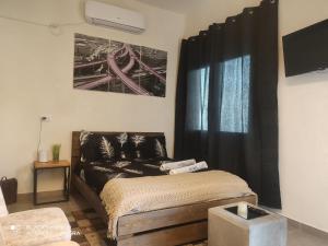 a bedroom with a bed and a black curtain at צימרים סוף העולם 3 in Ein Kinya