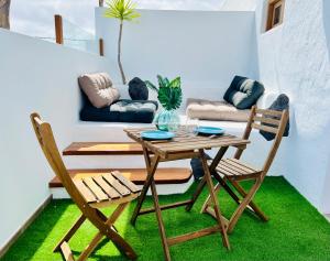 LeS OiSeauX في Nazaret: طاولة وكرسيين في غرفة معيشة مع أريكة