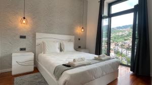 a bedroom with a white bed with a large window at Sea and Sun 4 You - Villa Oliveira in Funchal