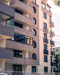 a tall building with round windows and a street light at MOZART RESIDENCE PLOIEȘTI Family and Business Apartment in Ploieşti