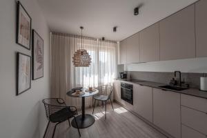 kuchnia z małym stołem i krzesłami w obiekcie BALI apartment in central Mažeikiai SELF CHECK-IN 24H w Możejkach