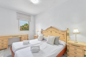 sypialnia z 2 łóżkami z białą pościelą i drewnianymi meblami w obiekcie Sandy Beach w Maladze