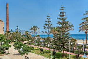 widok na park z palmami i ocean w obiekcie Sandy Beach w Maladze