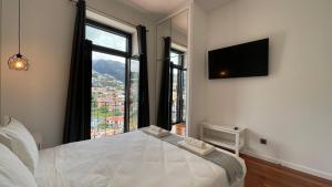 a bedroom with a bed and a large window at Sea and Sun 4 You - Villa Oliveira in Funchal