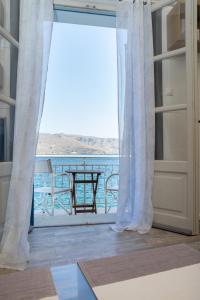 una puerta que da a un balcón con vistas al océano en ARTEMIS SUITE, en Agia Marina