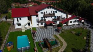 ein großes weißes Haus mit einem Hof und einem Pool in der Unterkunft Lacul de argint in Gura Râului