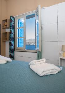 a bedroom with a bed with a window and towels at ARTEMIS SUITE in Agia Marina