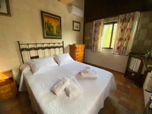 1 dormitorio con 1 cama blanca y 2 toallas en Villa Elisabeth, en Granada