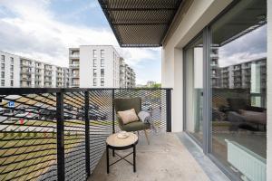 a balcony with a chair and a view of a city at Apartments 7vakarai with free parking in Vilnius