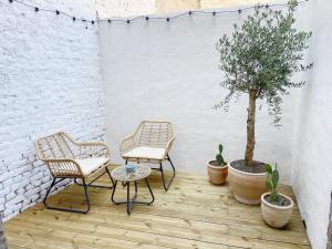 2 sillas, una mesa y un árbol en el patio en Le Santorini - centre ville & terrasse privée en Béthune