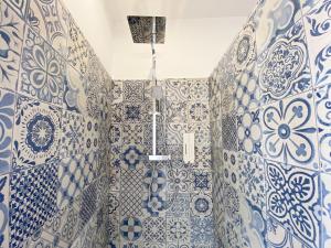 y baño con azulejos azules y blancos en las paredes. en Le Santorini - centre ville & terrasse privée en Béthune