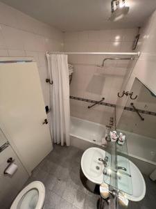 a bathroom with a toilet and a sink and a tub at Mojomar Pinamar Hotel in Pinamar