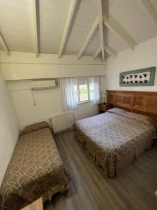 1 dormitorio con 2 camas y ventana en Mojomar Pinamar Hotel en Pinamar