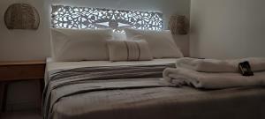 a bed with white sheets and pillows in a room at Niki Apartments in Makry Gialos