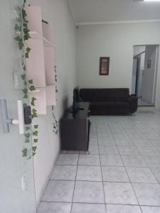 uma sala de estar com um sofá e piso em azulejo em FLAT 2 - CENTRO DE ITAPIRA em Itapira