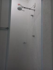 y baño con ducha y puerta de cristal. en FLAT 2 - CENTRO DE ITAPIRA, en Itapira