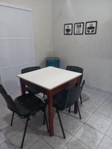 a table with four chairs in a room at FLAT 2 - CENTRO DE ITAPIRA in Itapira