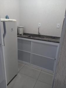 a kitchen with a sink and a refrigerator at FLAT 2 - CENTRO DE ITAPIRA in Itapira