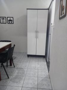 Pokój z białą szafką i podłogą wyłożoną kafelkami. w obiekcie FLAT 2 - CENTRO DE ITAPIRA w mieście Itapira