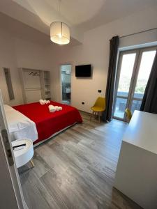 a bedroom with a red bed and a large window at MaLuNa in Castelsardo