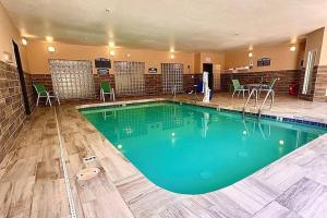 una gran piscina en un hotel con sillas y una mesa en Baymont by Wyndham Phoenix North en Phoenix