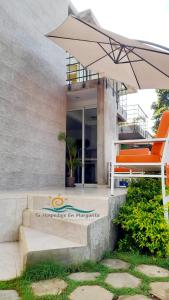 une terrasse avec une chaise orange et un parasol dans l'établissement Posada Villa Mayo Apartamento7 familiar a 5 Min de Playa Parguito, à Paraguchi