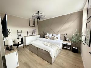ein Schlafzimmer mit einem großen Bett und einem Schreibtisch in der Unterkunft Ferienwohnung Domizil am Delft II Emden in Emden