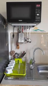 fregadero de cocina con tendedero de platos y microondas en Posada Villa Mayo Apartamento7 familiar a 5 Min de Playa Parguito, en Paraguchi