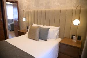 a bedroom with a bed with white sheets and pillows at Hotel Victoria in Lagos de Moreno