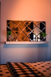 a mirror on a wall with two plants at MOZART RESIDENCE PLOIEȘTI Family and Business Apartment in Ploieşti