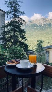 a table with a plate of food and a glass of orange juice at Palestro 8_Art Holiday House in Caramanico Terme